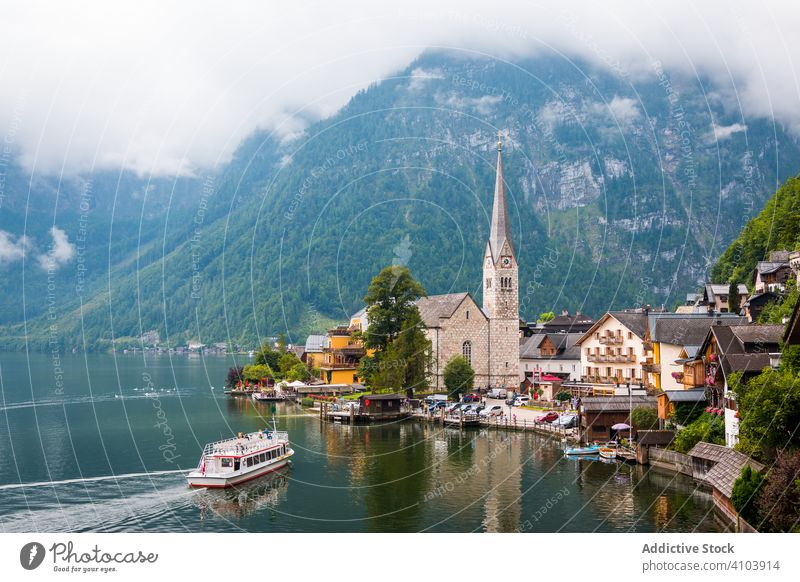 Ruhiger See und Stadt in der Nähe der Berge Berge u. Gebirge Windstille Ufer wolkig tagsüber Landschaft Wasser Österreich malerisch Haus Architektur Außenseite