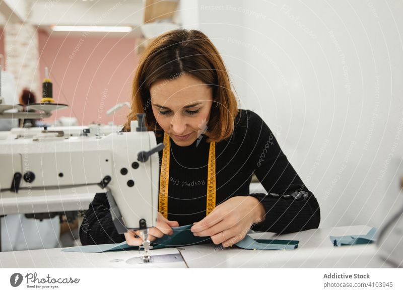 Nähen mit der Nähmaschine in der Werkstatt Näherin Arbeit Frau nähen Gewebe Handwerk Beruf Material Bekleidung Maschine Erwachsener Schneider Scheitel Element