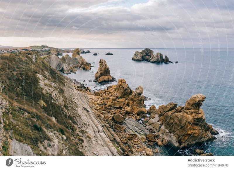 Steinerne Gipfel und Meeresufer und schäumende Wellen unter bewölktem Himmel MEER Landschaft Ufer Wasser Natur reisen malerisch wolkig Kantabrien Santander