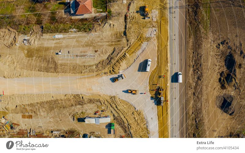 Luftaufnahme auf Grader beim Nivellieren von Sand über der Baustelle für den neuen Verkehrskreisel oben Antenne Ausrichten Ausrichtung Basis kreisen kreisrund