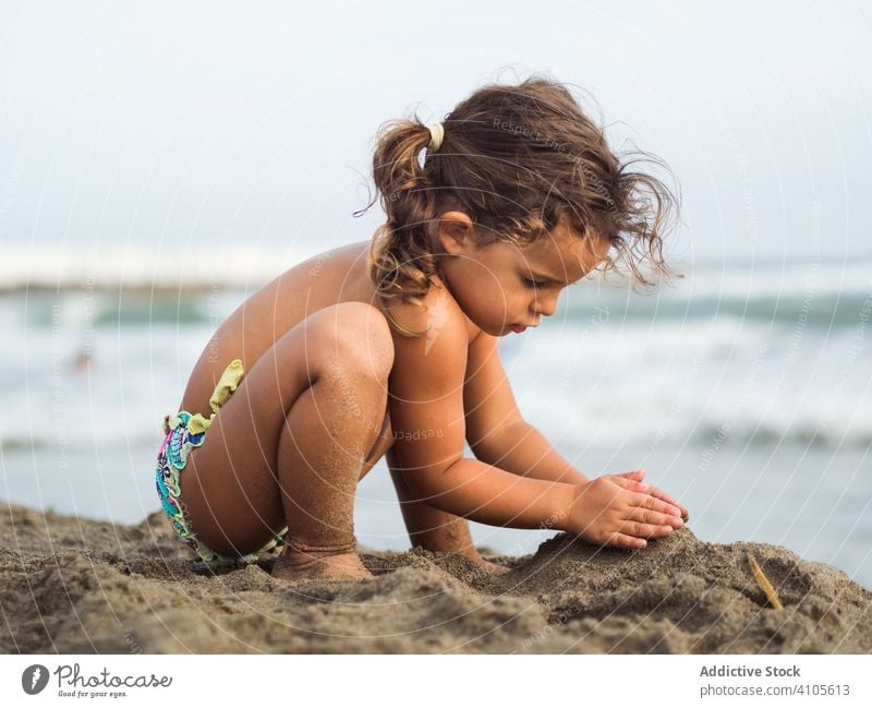 Kleines Mädchen baut Sandburg am Strand spielen MEER Burg oder Schloss Haufen sitzen Lenden Kind Sommer Urlaub Saison Meer Wasser Lifestyle ruhen