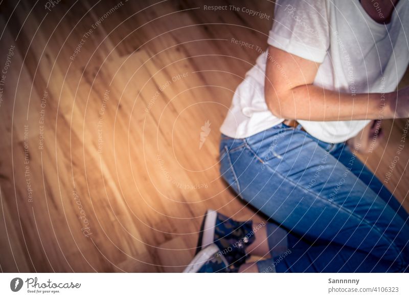 Frau auf dem Fußboden seitlich sitzend Pause fußboden gemütlich von oben Jeanshose lazy