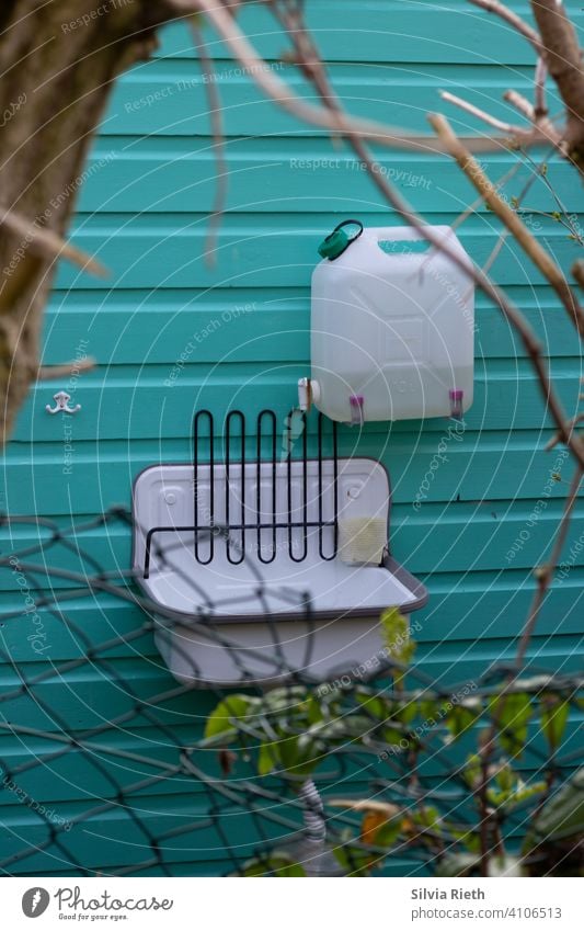 Außenwaschbecken bei einer Gartenlaube Schrebergarten Hütte Gartenhütte Außenaufnahme Menschenleer Farbfoto Gartenhaus Tag Natur Türkis Kanister Waschbecken