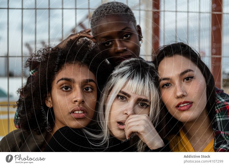 Diverse Gruppe von lächelnden Frauen, die sich auf dem Rasen umarmen Freund umarmend Menschengruppe Lächeln Lachen Kuscheln lässig Spaß Zusammensein jung