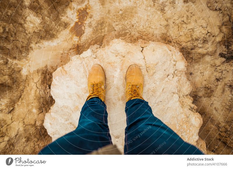 Anonymer Tourist zwischen Wüste mit Klippen Reisender Tourismus wüst Beine Stiefel Berge u. Gebirge Jeanshose lässig Hügel Himmel wandern Trekking Abenteuer