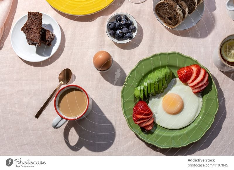 Hausgemachter vollwertiger Brunch gesundes Frühstück im Sonnenlicht Avocado Tisch Trinksprüche trinken organisch gekocht Hintergrund Tee sonnig Tasse