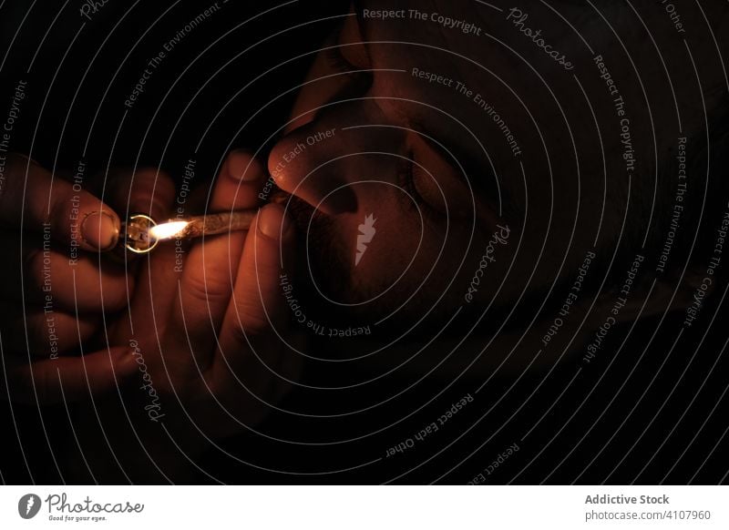 Erwachsener Mann raucht Cannabis-Joint Rauch Gelenk Raucherin stumpf Feuerzeug Licht Marihuana Unkraut Medikament männlich ganja medizinisch hoch Erholung Dope