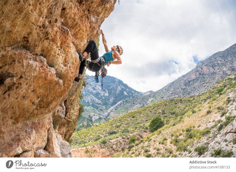 Unerkennbare Bergsteigerin, die im Sommer an einem steilen Felsen aufsteigt Aufsteiger aufsteigen steile Klippe Frau Alpinist Berge u. Gebirge üben Klettern