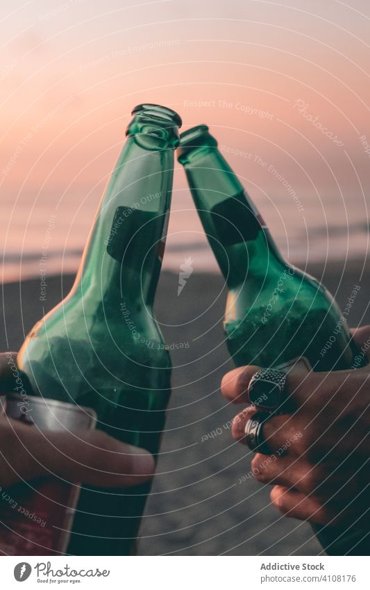 Freunde stoßen am Strand bei Sonnenuntergang mit Bier an Flasche Zuprosten Sommer MEER Himmel Hand Klirren Zusammensein sich[Akk] entspannen genießen trinken