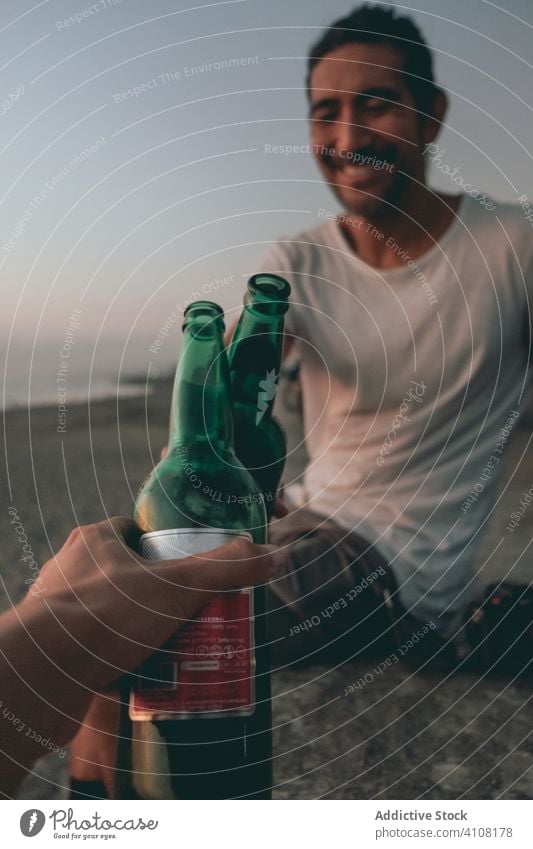 Freunde stoßen am Strand bei Sonnenuntergang mit Bier an Flasche Zuprosten Sommer MEER Himmel Hand Klirren Zusammensein sich[Akk] entspannen genießen trinken