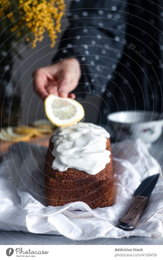 Hausfrau dekoriert Kuchen mit Zitronenscheiben selbstgemacht dekorieren Scheibe Hand Frau Lebensmittel backen Gebäck Zitrusfrüchte Zuckerguß geschmackvoll Küche