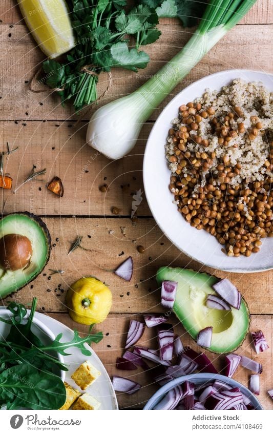 Verschiedene Gemüsesorten und Zutaten auf rustikalem Tisch Bestandteil geschnitten Zwiebel Avocado Süßkartoffel Prozess Vorbereitung Suppengrün Lebensmittel