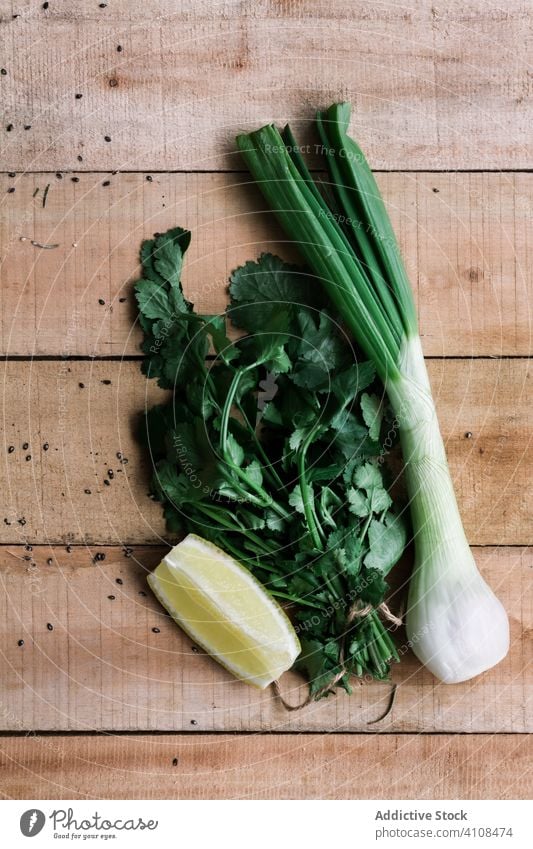 Frische grüne Zwiebeln und Petersilie mit Zitrone auf dem Tisch Frühlingszwiebel frisch roh Haufen hölzern Bestandteil Lebensmittel Gemüse Mahlzeit Amuse-Gueule