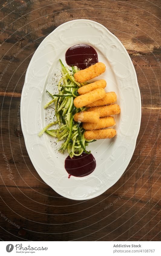 Gegrillte Käsesticks mit Gurke und Sauce gebraten Stöcke Saucen Ketchup Snack Fastfood grillen Salatgurke dienen Lebensmittel Teller gegrillt Mahlzeit