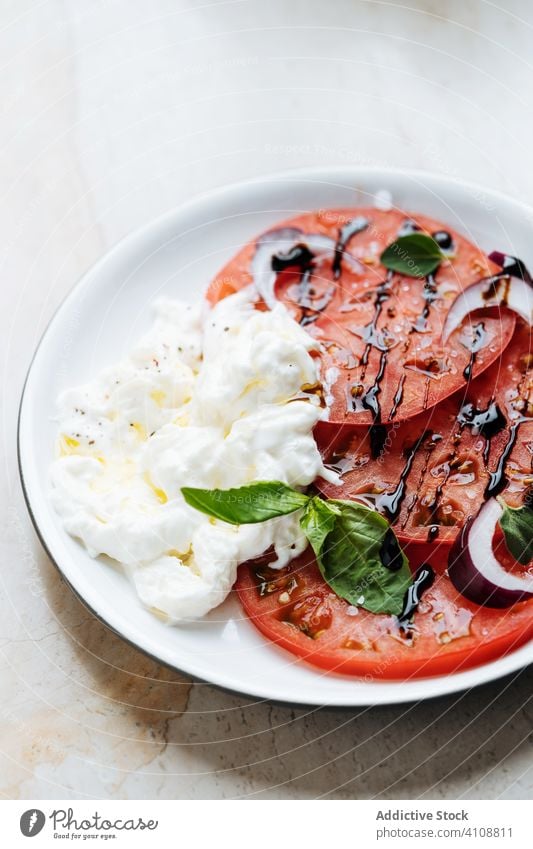 Tomatensalat mit Zwiebeln und saurer Sahne im Teller Salatbeilage grün Sauerrahm geschmackvoll Speise Feinschmecker lecker Lebensmittel Küche frisch Mahlzeit