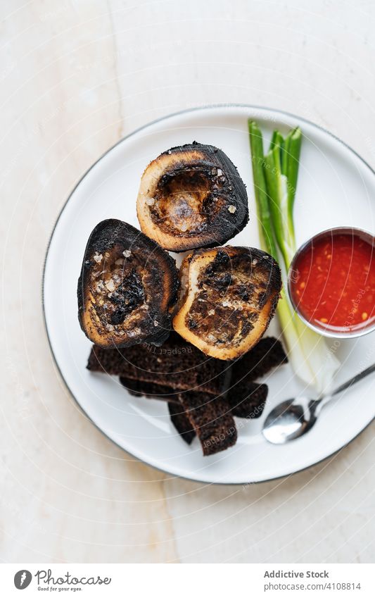 Aperitif der hohen Küche im Restaurant Amuse-Gueule Snack Croutons rustikal Saucen Teller Tisch Frühlingszwiebel Löffel Knusprig gebraten geräuchert Spielfigur