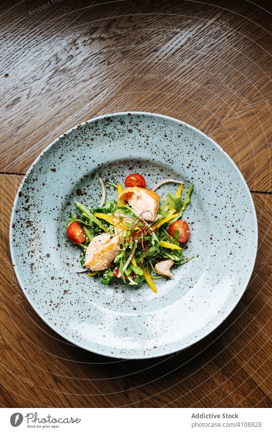 Salat der gehobenen Küche mit Huhn im Restaurant Salatbeilage Gemüse Haute Cuisine Tomate Salatgurke Filet Hähnchen organisch Ernährung Teller geschmackvoll