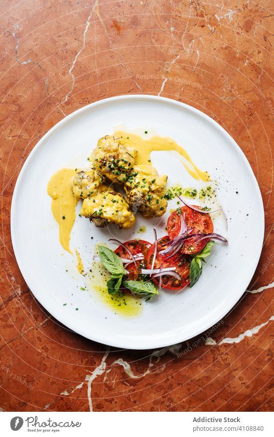 Fleisch mit Tomate schön serviert mit Sauce Speise Haute Cuisine Restaurant Saucen farbenfroh rote Zwiebel Kraut Minze Teller Tisch Dienst Gewürz Scheibe