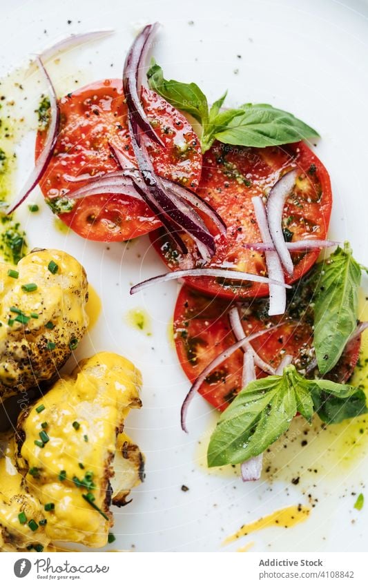 Fleisch mit Tomate schön serviert mit Sauce Speise Haute Cuisine Restaurant Saucen farbenfroh rote Zwiebel Kraut Minze Teller Tisch Dienst Gewürz Scheibe