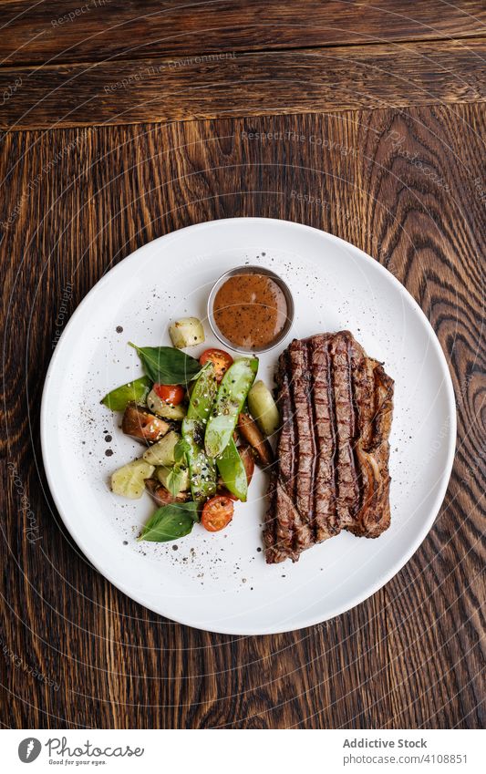 Köstliches gegrilltes Rindersteak mit Gemüse auf einem Teller Basilikum grillen dienen Saucen Lebensmittel Fleisch Speise Mahlzeit geschmackvoll lecker Küche