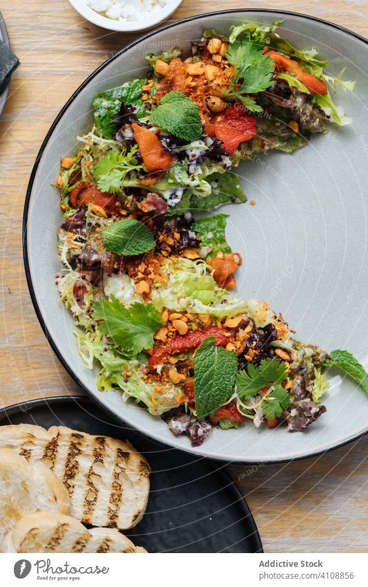 Salat der gehobenen Küche mit Meeresfrüchten und Brot im Restaurant Salatbeilage Haute Cuisine Teller Speise Octopus Tomaten gebraten Scheibe Spielfigur