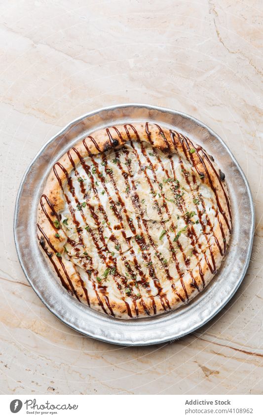 Runde Pizza mit Bananen und Schokoladensauce auf Metalltablett Dessert süß Saucen Nut zerdrückt Minze Belag Zucker Pasteten Konditorei Feinschmecker lecker