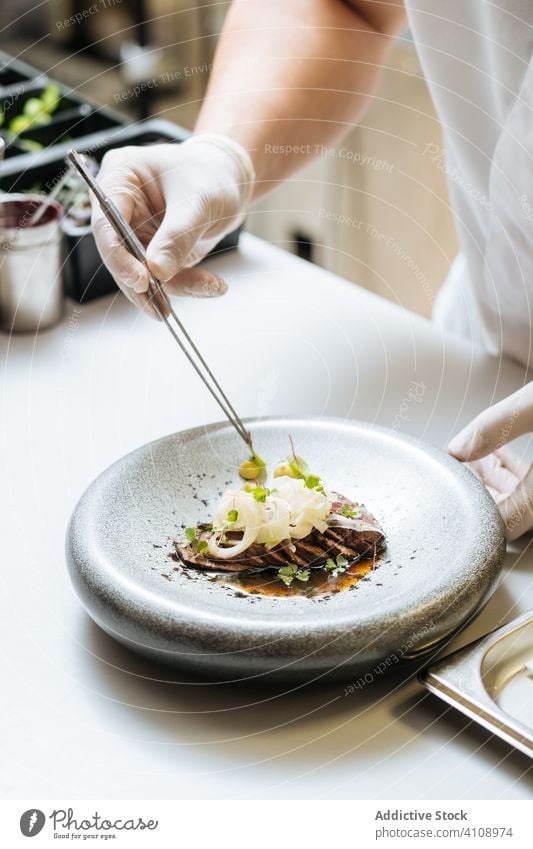 Gesichtsloser Koch serviert Gericht der Haute Cuisine in einem Restaurant Küchenchef dienen Speise dekorieren gebraten Rindfleisch Lebensmittel Mahlzeit lecker