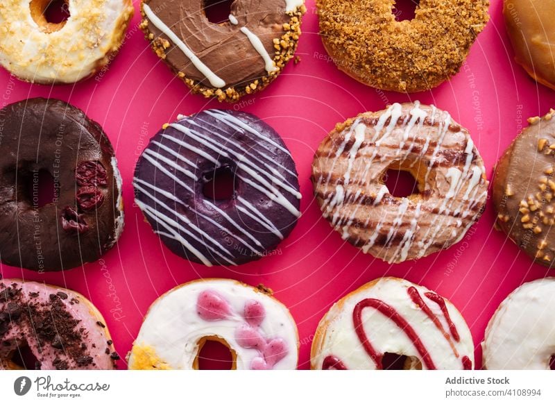 Vielfalt von Donuts auf rosa Hintergrund Doughnut Varieté Sortiment süß Zuckerguß verglast Lebensmittel Krapfen Bäckerei Gebäck bestäuben gebraten farbenfroh