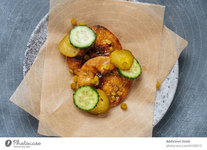 Gericht der hohen Küche mit Gurken Hohe Küche Speise Delikatesse Haute Cuisine Salatgurke eingelegt Saucen Backpapier Teller Tisch frisch Gemüse Lebensmittel