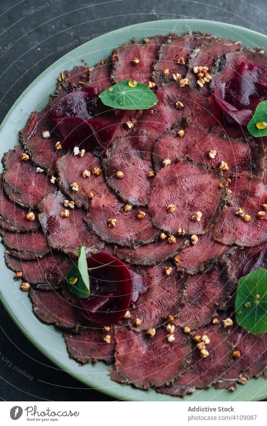 Teller mit leckerem Carpaccio im Cafe Fleisch roh Scheibe Restaurant Rote Beete Exquisit kalt Feinschmecker Amuse-Gueule Speise Lebensmittel geschmackvoll