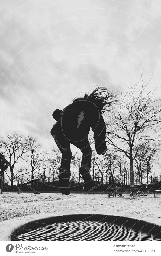 Silhouette eines Mädchens, dass auf einem Trampolin springt springen Spielplatz spielen Trampolinspringen Kind Spaß Freude Lebensfreude Sport Freizeit Kindheit