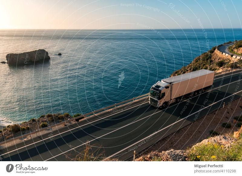 LKW mit Kühlsattelauflieger fährt auf einer Straße am Meer. camion Refigerado mar Anhänger Playa Transporte Perecederos remolque Karretera montaña Logística