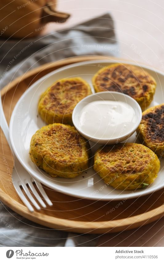 Köstliche Gemüseschnitzel mit saurer Sahne auf dem Tisch Kotelett Kürbis traditionell gebraten golden Küche Speise lecker Feinschmecker Teller Mahlzeit