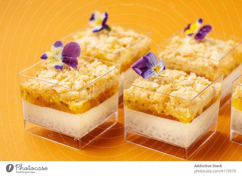 Behälter mit leckerem Dessert, dekoriert mit Blumen Tasse süß Dekor Lebensmittel Gebäck geschmackvoll Küche Speise Zucker Kalorie Portion gebacken Feinschmecker