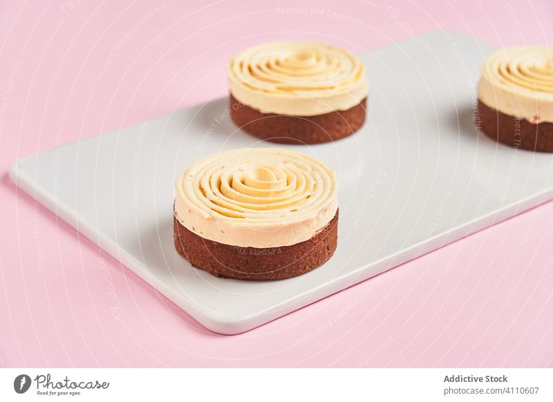 Leckere Desserts mit Sahnespirale süß Spirale Dekor Lebensmittel Gebäck Holzplatte geschmackvoll Küche Speise lecker Zucker Kalorie Portion Spielfigur gebacken