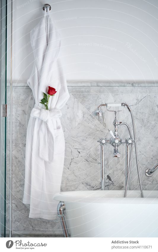 Vintage-Innenarchitektur eines hellen, gemütlichen Badezimmers in einem Hotelzimmer Innenbereich altehrwürdig Bademantel Roséwein Dusche Badewanne Appartement