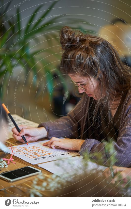 Künstlerin zeichnet mit Bleistift im Kunstatelier Frau Beschriftung Handschrift zeichnen Konzentration kreativ Fokus Lifestyle lernen Job sitzen Skizze