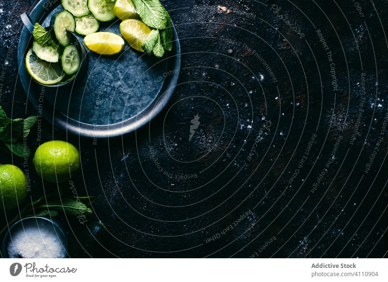 Zutaten für Gurken-Detox-Getränk auf dem Tisch Salatgurke Entzug trinken Bestandteil Kalk Minze Zucker Zitrone Tasse Tablett dunkel frisch Gesundheit natürlich