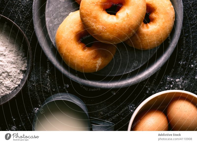 Doughnuts in der Nähe von Zutaten auf dem Tisch Bestandteil Koch Küche Rezept Mehl melken Ei Utensil Gebäck Lebensmittel Serviette Löffel geschmackvoll lecker