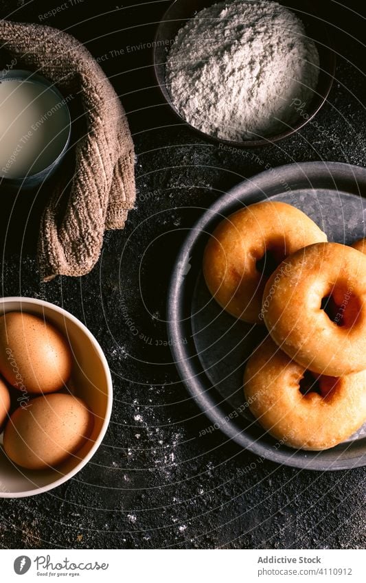 Doughnuts in der Nähe von Zutaten auf dem Tisch Bestandteil Koch Küche Rezept Mehl melken Ei Utensil Gebäck Lebensmittel Serviette Löffel geschmackvoll lecker