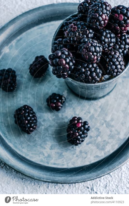 Frische Brombeeren im Becher und auf dem Tablett Tasse frisch reif rustikal organisch Lebensmittel süß Ernte Beeren lecker geschmackvoll Dessert natürlich