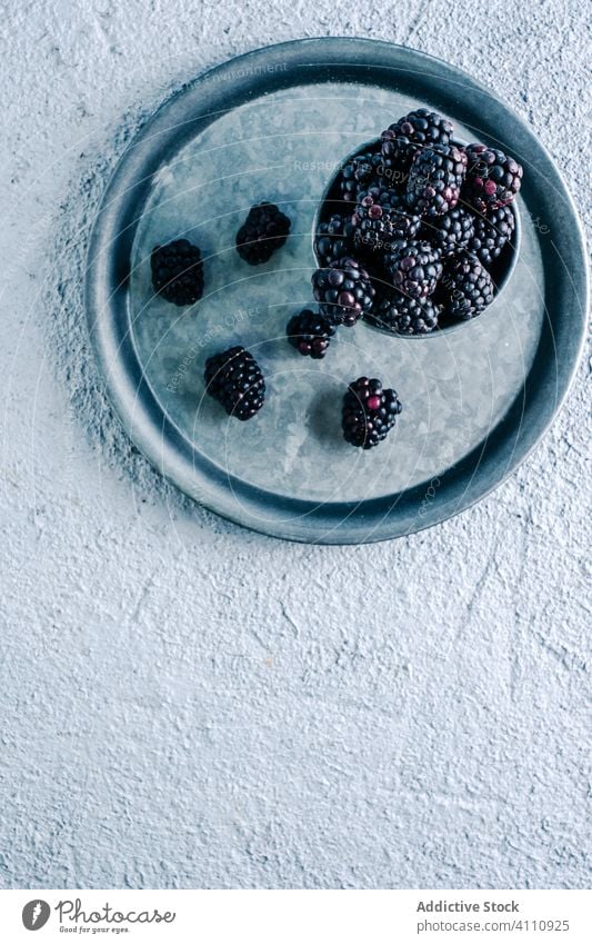 Frische Brombeeren im Becher und auf dem Tablett Tasse frisch reif rustikal organisch Lebensmittel süß Ernte Beeren lecker geschmackvoll Dessert natürlich