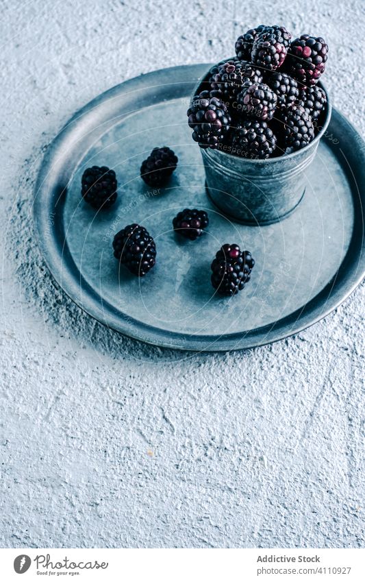 Frische Brombeeren im Becher und auf dem Tablett Tasse frisch reif rustikal organisch Lebensmittel süß Ernte Beeren lecker geschmackvoll Dessert natürlich