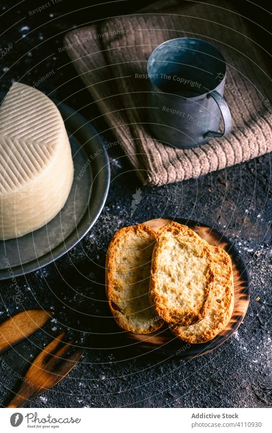 Käse und Toast auf unordentlichem Tisch Zuprosten Küche Lebensmittel Utensil Serviette rustikal geschmackvoll Mahlzeit selbstgemacht Feinschmecker frisch lecker