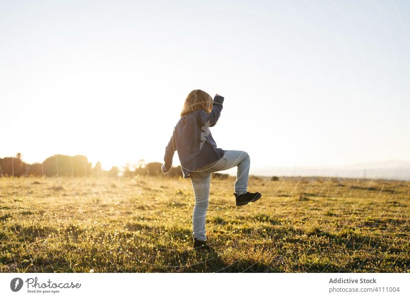 Kleines Mädchen hat Spaß im Feld Kind Glück Natur genießen Spaß haben spielen Tanzen Sonnenuntergang Wiese Landschaft Freiheit Gras Sommer Freude sorgenfrei