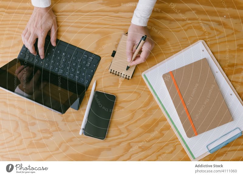 Gesichtslose Geschäftsfrau mit Tablet und Notizblock Tablette Arbeitsplatz schreiben zur Kenntnis nehmen Holz Beruf Business Gerät Tastenfeld Tippen Keyboard