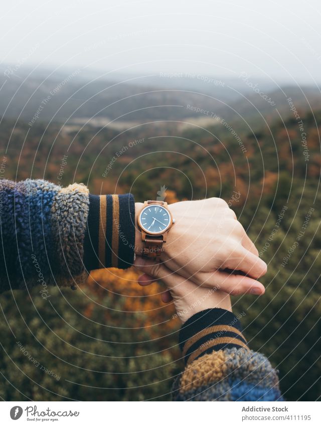 Reisender, der die Zeit auf seiner Armbanduhr überprüft zuschauen reisen Hand modern Stil trendy Natur Wald Hügel Herbst prüfen Tourismus Abenteuer Urlaub