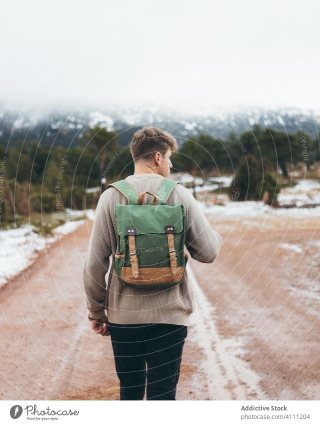 Mann mit Rucksack zu Fuß auf Landstraße reisen Straße ländlich Landschaft Natur Reise Schmutz Abenteuer kalt Herbst Winter Schnee Wald männlich Freiheit