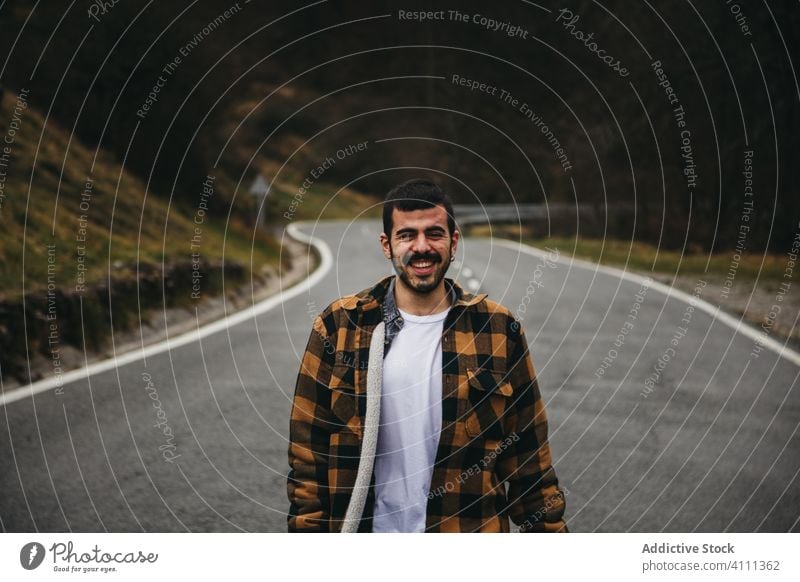 Glücklicher männlicher Reisender auf der Straße Mann Natur reisen Lächeln Landschaft Lachen genießen Asphalt jung Stil Tourismus Route sich[Akk] entspannen