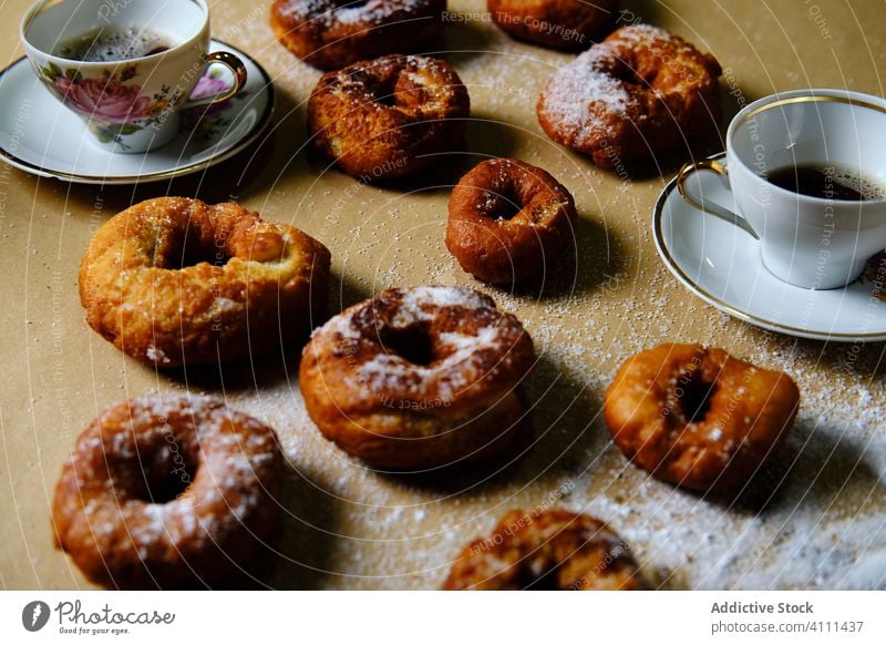 Süße Donuts und Tee auf dem Tisch Krapfen süß Zucker heimwärts Tasse Untertasse Lebensmittel lecker Dessert Gebäck geschmackvoll frisch Frühstück Snack